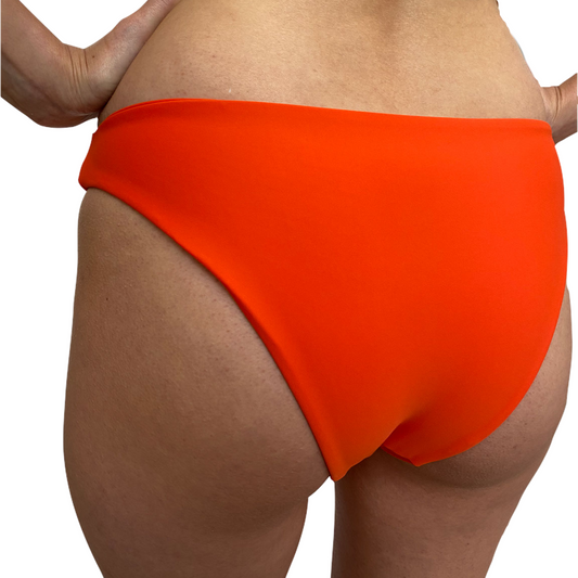 An orange bikini bottom with a cheeky cut, V dip front design, made from OEKO-TEX certified fabric.